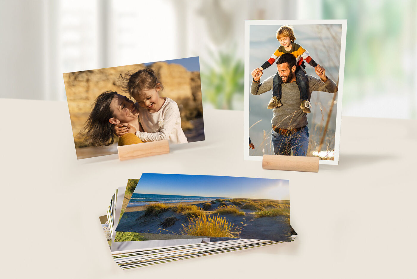 Zwei Fotos auf einem Tisch, das eine zeigt ein Kind und das andere eine Person mit einem Kind auf den Schultern. Darunter liegen weitere Fotos.